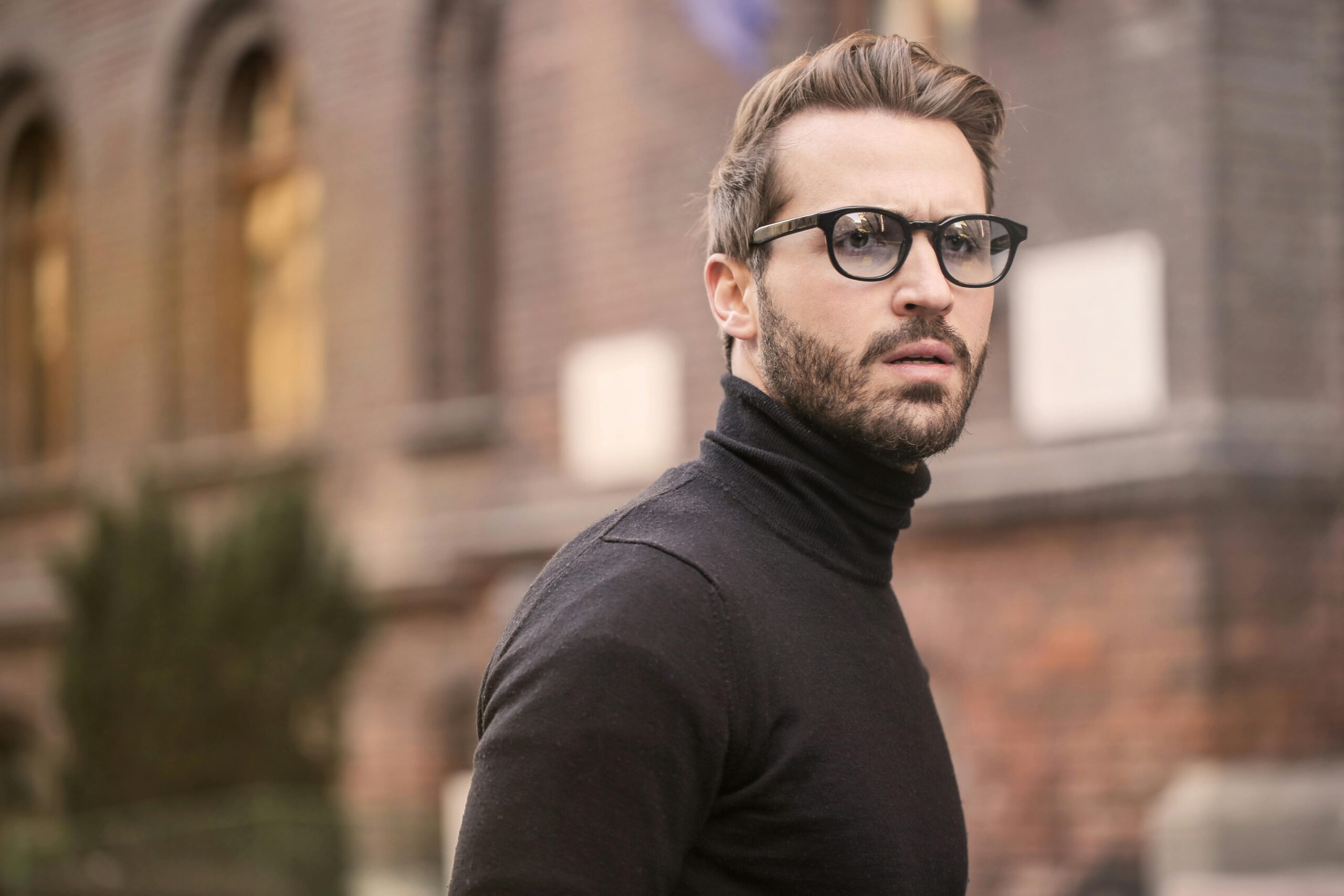 A fashionable man with glasses and a beard captured outdoors in Budapest.